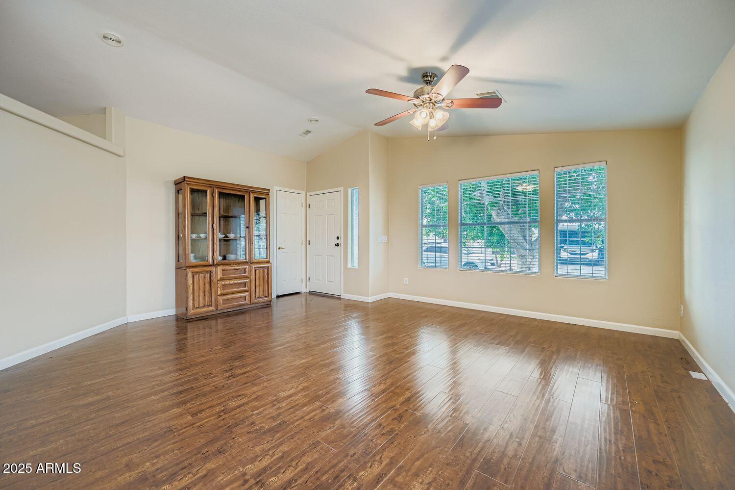 2550 South Ellsworth Road, Unit 277 Mesa, AZ 85209 - Photo 3 of 20 a view of an empty room with wooden floor and a window