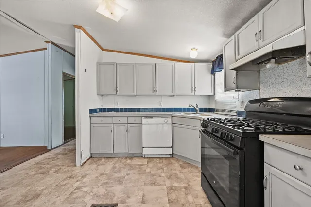 a kitchen with granite countertop a stove top oven sink and cabinets