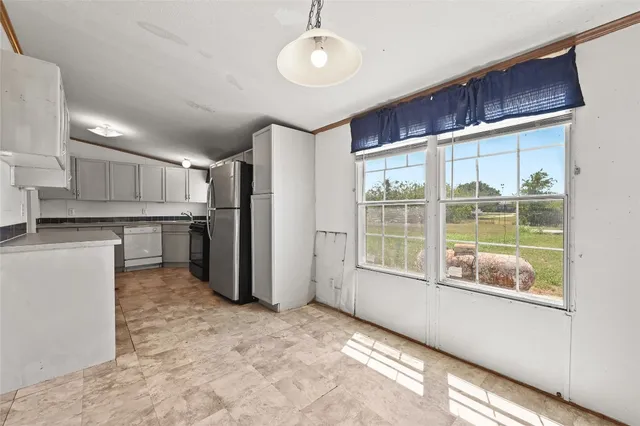a view of a kitchen with a refrigerator cabinets and a window