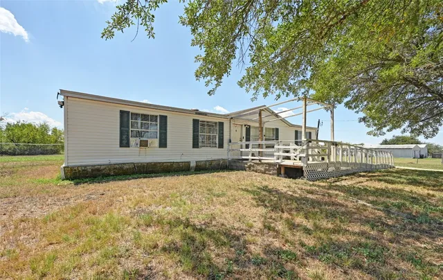 a view of a house with backyard and sitting area