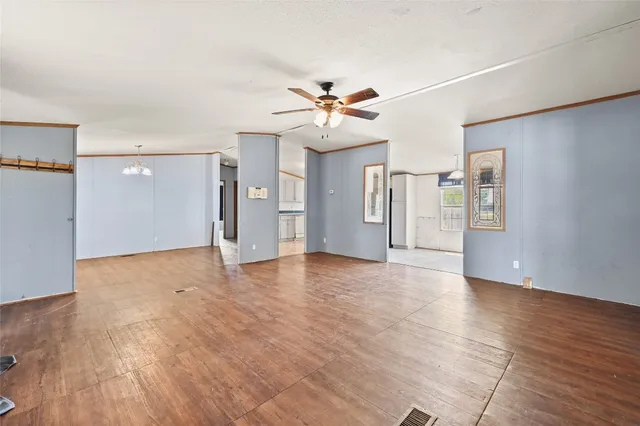 a view of an empty room with window and wooden floor
