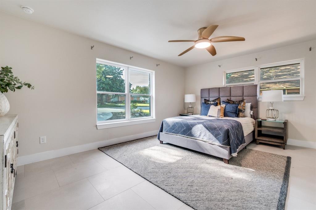 7115 Meadow Road Dallas, TX 75230 - Photo 14 of 22 Well-appointed room featuring light-toned flooring, a modern ceiling fan with lighting, and windows providing natural light