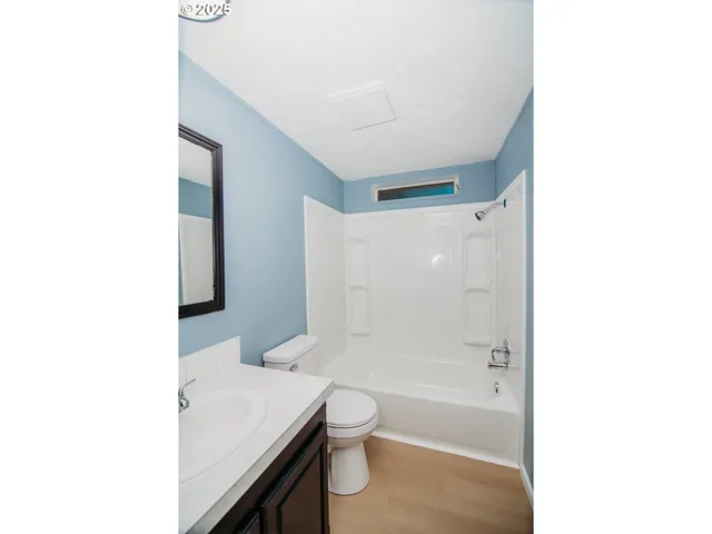 a bathroom with a granite countertop sink a toilet and shower