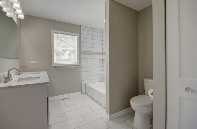 a bathroom with a sink toilet and window
