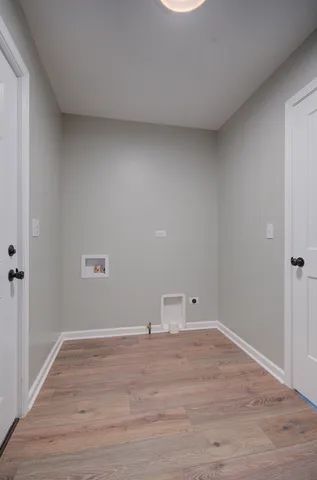 a view of storage and utility room with wooden floor