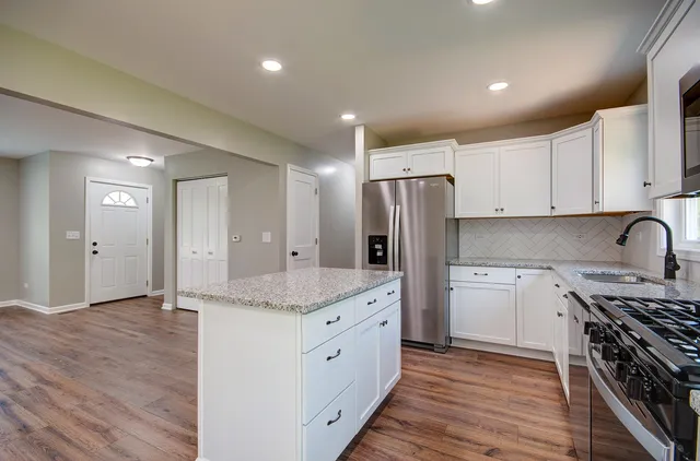 a kitchen with stainless steel appliances granite countertop a sink stove and refrigerator