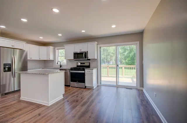 a kitchen with refrigerator a stove top oven and sink