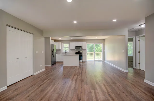 a view of a kitchen with wooden floor and a window