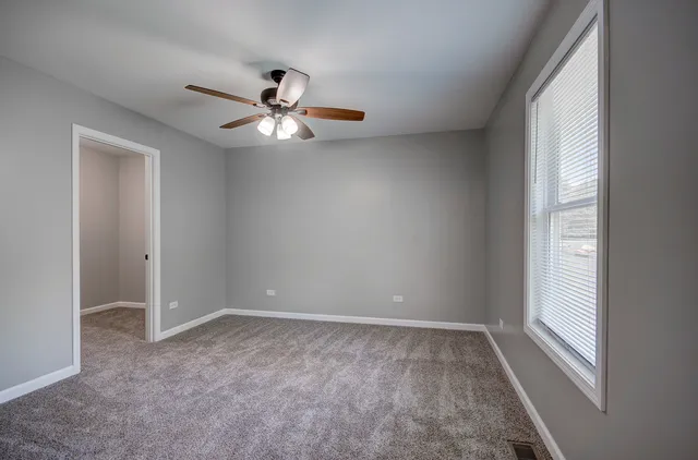 a view of room with a ceiling fan and window