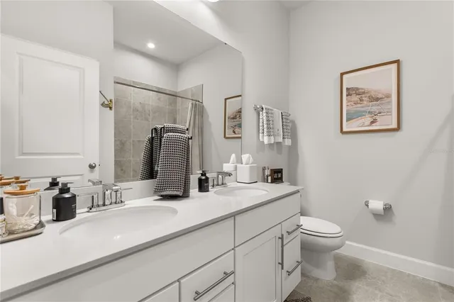 a bathroom with a granite countertop sink mirror vanity and toilet