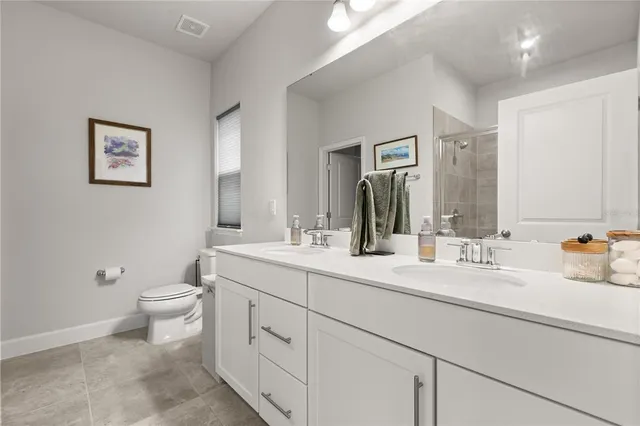 a bathroom with a double vanity sink mirror and toilet