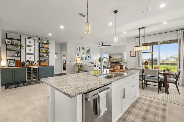 a kitchen with stainless steel appliances granite countertop a kitchen island a stove and a sink