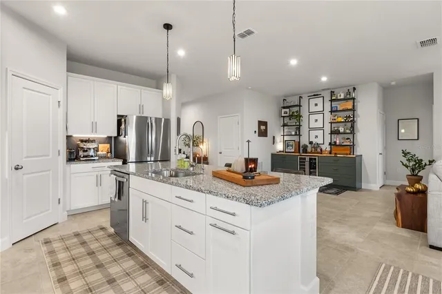 a kitchen with kitchen island granite countertop a sink a counter top space appliances and cabinets