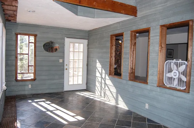 a view of empty room with wooden floor and floor to ceiling window