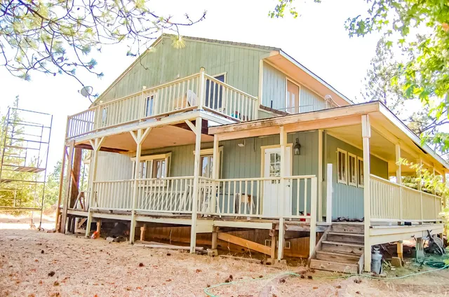 a view of a house with a small yard and wooden fence