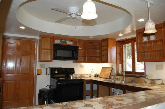 a kitchen with a sink and a stove top oven with wooden floor