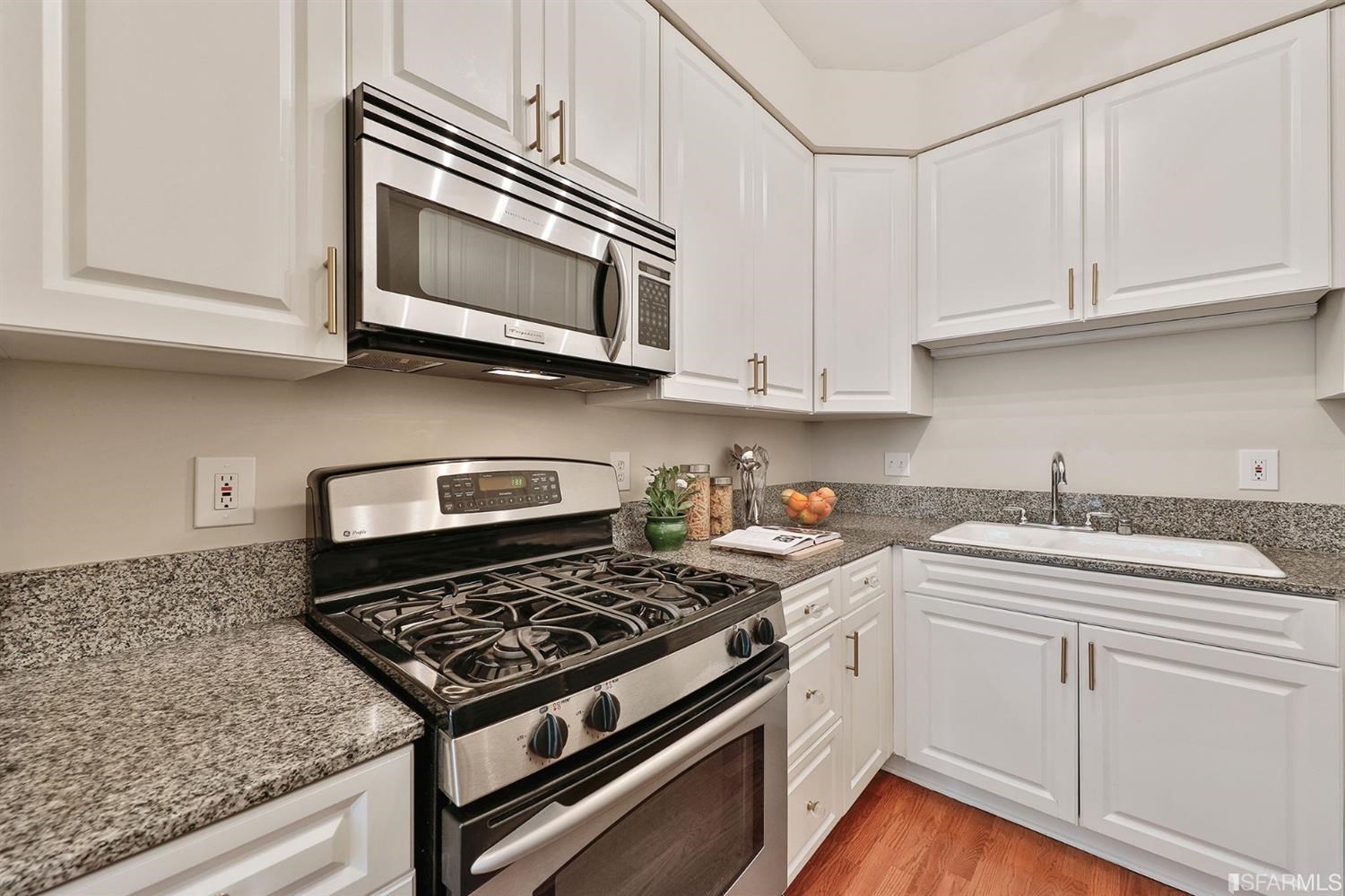 261 Henry Street, Unit A San Francisco, CA 94117 - Photo 15 of 64 a kitchen with stainless steel appliances granite countertop a stove a microwave and cabinets