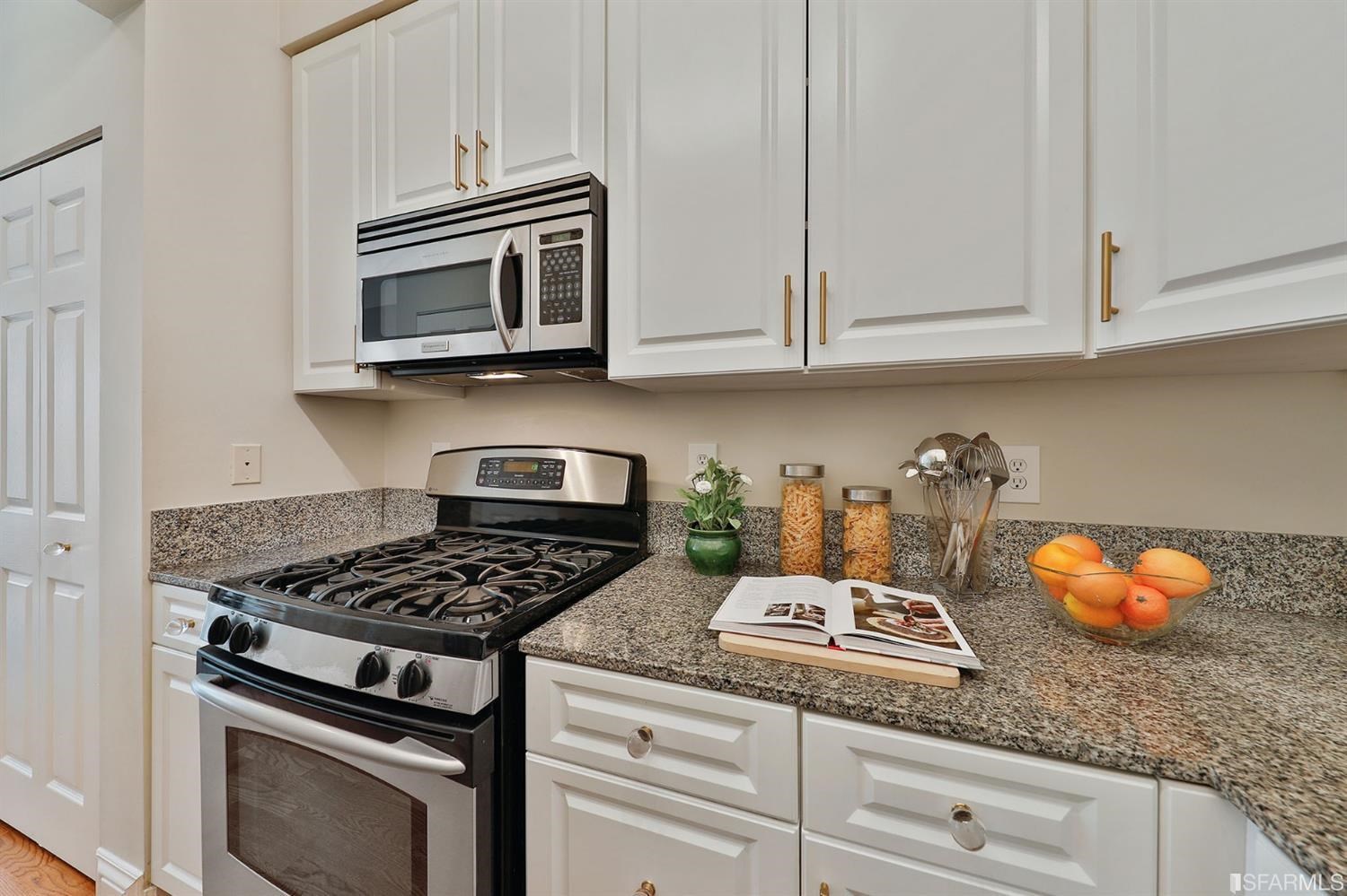 261 Henry Street, Unit A San Francisco, CA 94117 - Photo 16 of 64 a kitchen with granite countertop white cabinets and stainless steel appliances