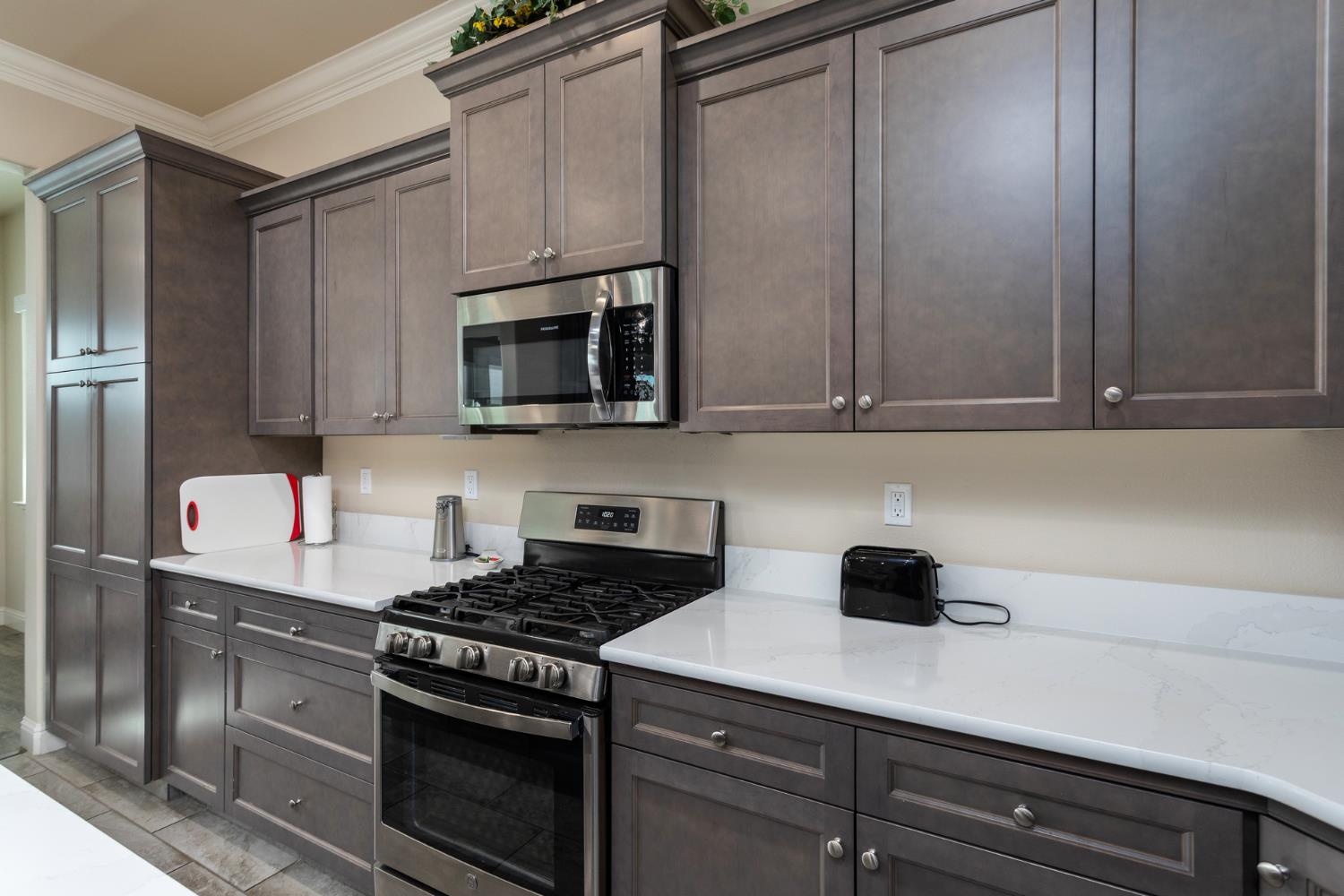 2227 North Highland Avenue Clovis, CA 93619 - Photo 11 of 48 a kitchen with stainless steel appliances a stove a microwave and cabinets