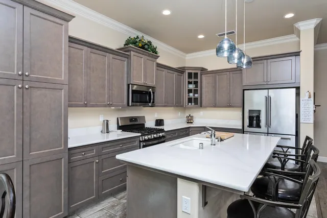 a kitchen with kitchen island a sink appliances and cabinets