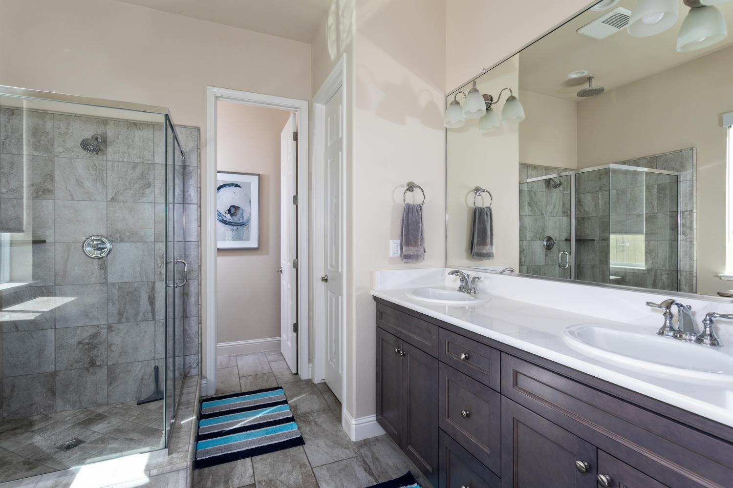 2227 North Highland Avenue Clovis, CA 93619 - Photo 19 of 48 a bathroom with a shower sink and mirror