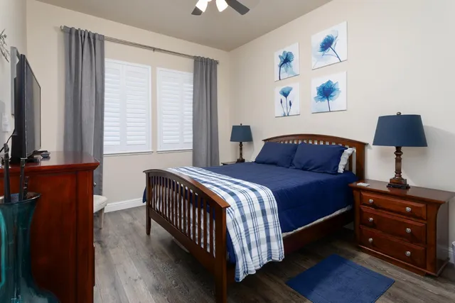 a bedroom with a bed and a lamp on dresser