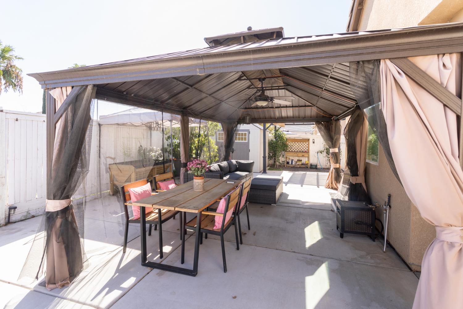 2227 North Highland Avenue Clovis, CA 93619 - Photo 37 of 48 a view of a patio with table and chairs under an umbrella with a small yard