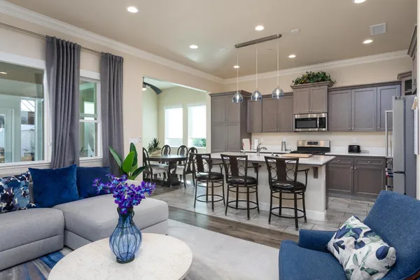 a kitchen with granite countertop kitchen island stainless steel appliances a sink and living room
