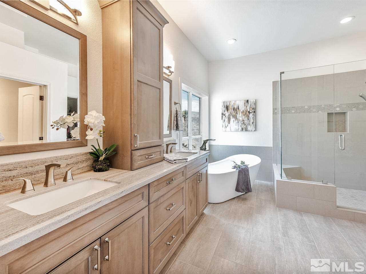 300 Andrew Lane Reno, NV 89521 - Photo 11 of 25 a spacious bathroom with a double vanity sink a large mirror and a bathtub
