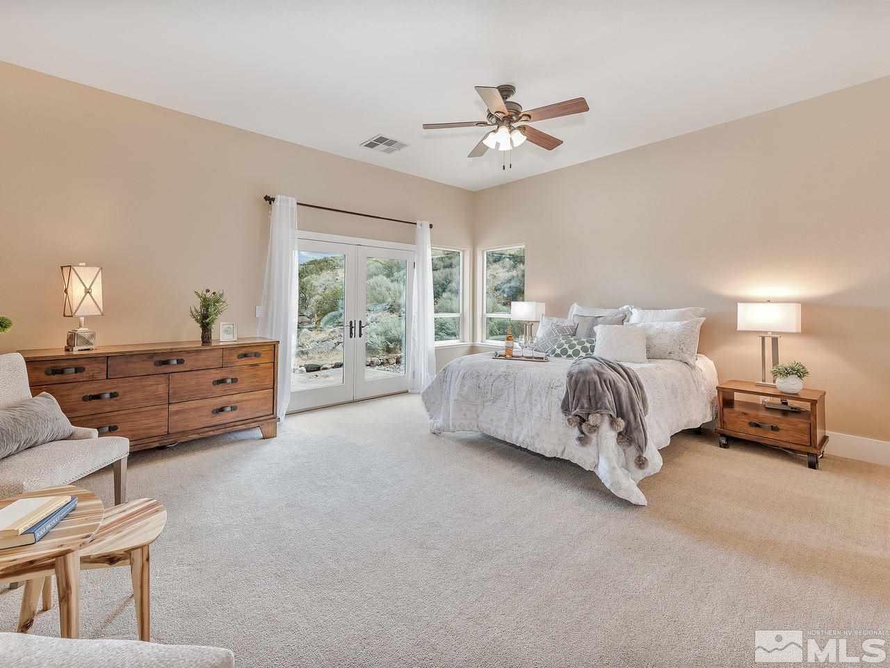 300 Andrew Lane Reno, NV 89521 - Photo 9 of 25 a spacious bedroom with a bed and a chandelier
