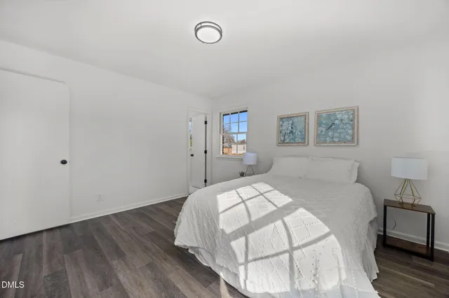 a bedroom with a bed and a painting on the wall