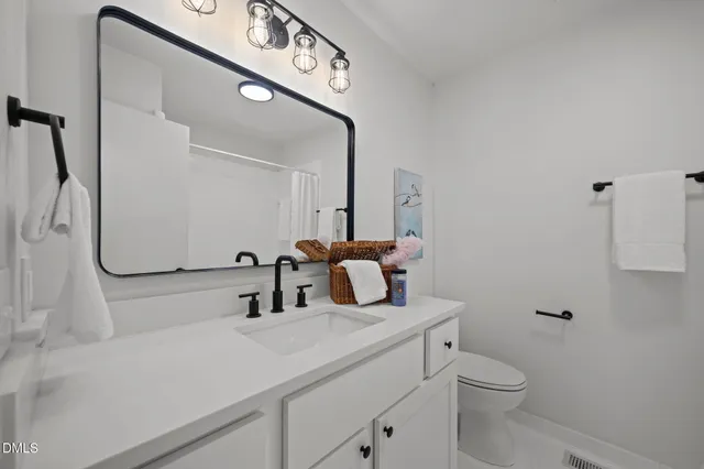 a bathroom with a sink a toilet and a mirror