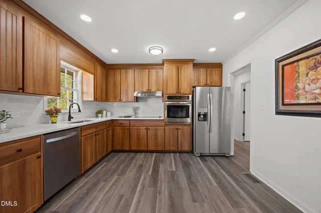 a kitchen with a refrigerator a sink and wooden cabinets
