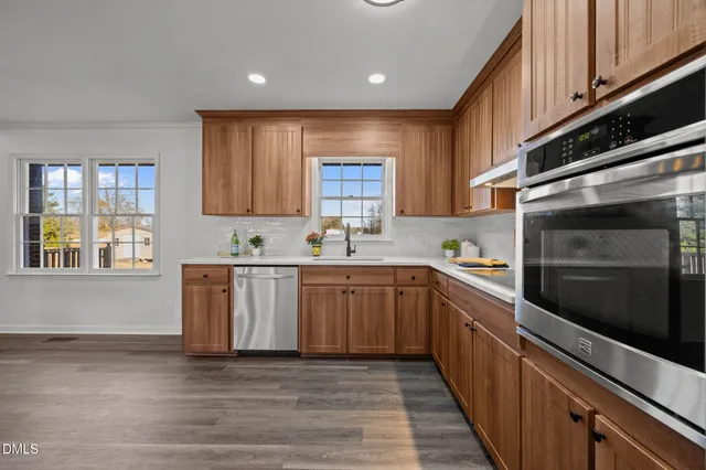 a kitchen with stainless steel appliances granite countertop a stove a sink and a microwave
