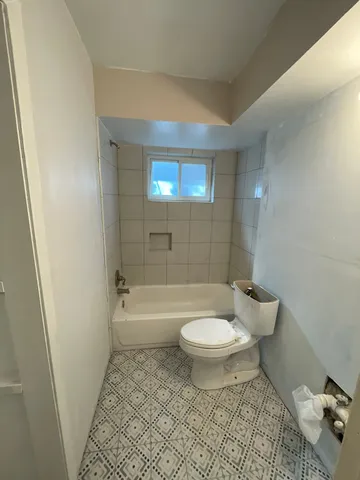 a bathroom with a sink a toilet a mirror and bathtub