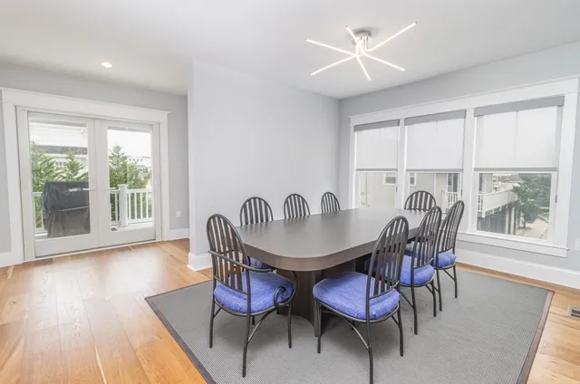 a dining room with stainless steel appliances kitchen island granite countertop a table chairs and a living room view