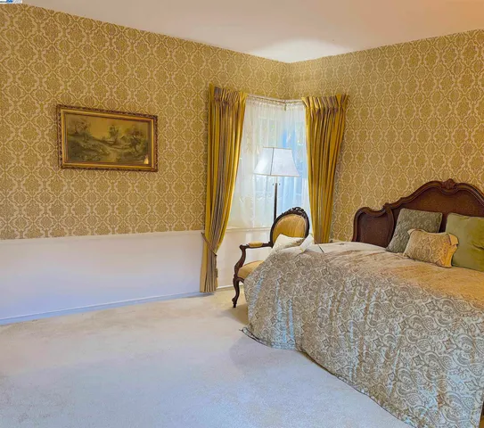 a bedroom with a bed and a painting on the wall