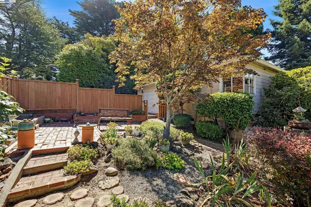 a view of a backyard with sitting area and garden