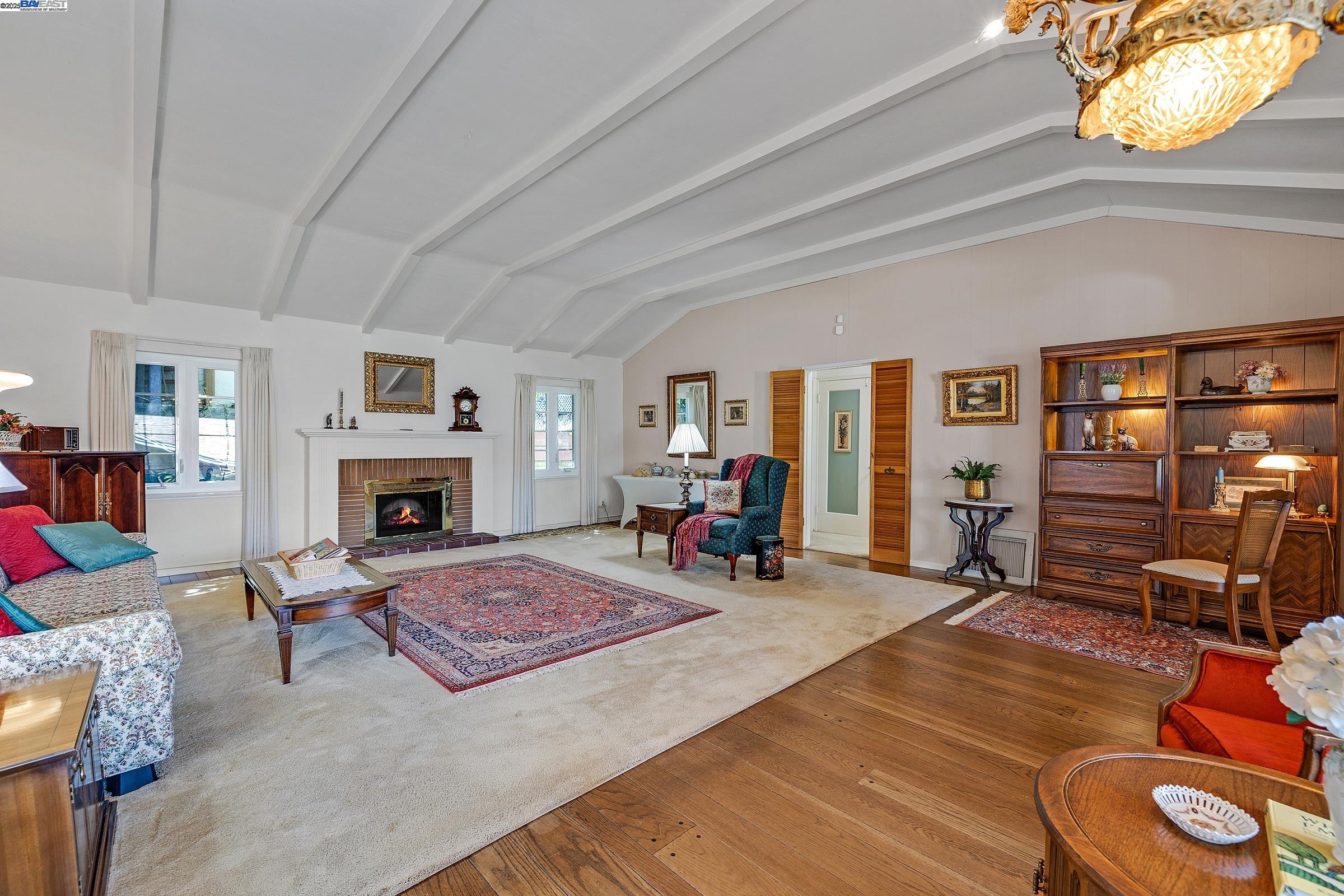 2863 Burton Drive Oakland, CA 94611 - Photo 10 of 34 a living room with furniture a fireplace and a large window