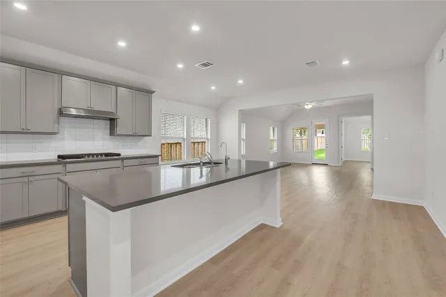 a kitchen with stainless steel appliances granite countertop a sink stove and cabinets