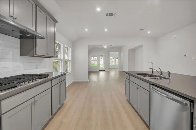 a large kitchen with stainless steel appliances granite countertop a large counter top and a stove top oven