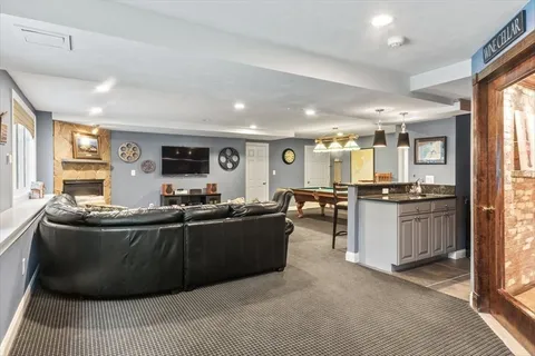 a living room with stainless steel appliances kitchen island granite countertop furniture and a large window