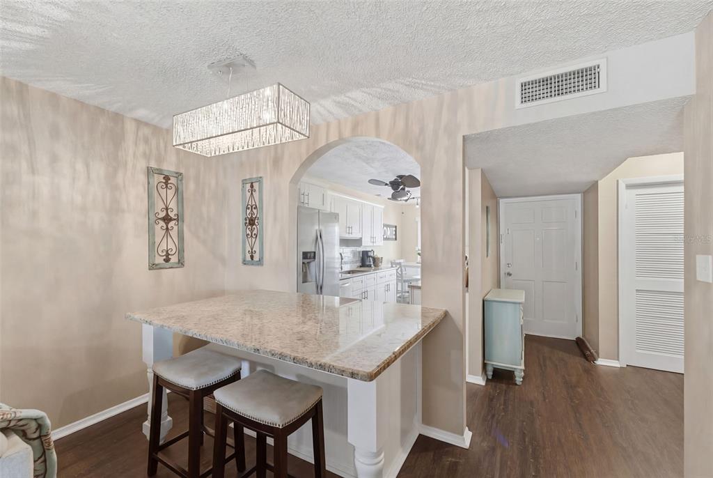 2074 Sunset Point Road, Unit 137 Clearwater, FL 33765 - Photo 15 of 32 a view of a kitchen area with furniture and wooden floor