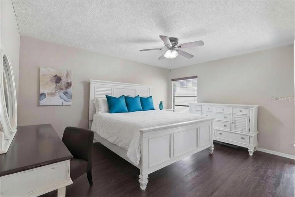 2074 Sunset Point Road, Unit 137 Clearwater, FL 33765 - Photo 18 of 32 a bedroom with a bed and a chandelier