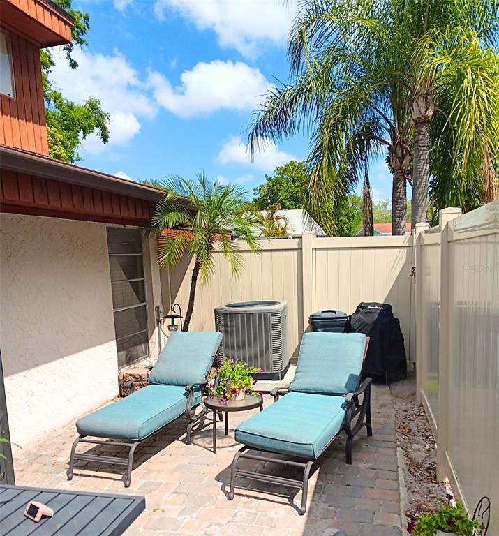 2074 Sunset Point Road, Unit 137 Clearwater, FL 33765 - Photo 26 of 32 a view of a patio with couches chairs and a potted plant