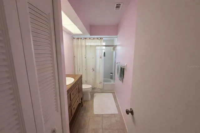 a bathroom with a granite countertop double vanity sink and a mirror