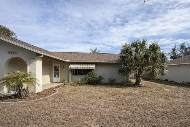 a front view of house with yard and trees around