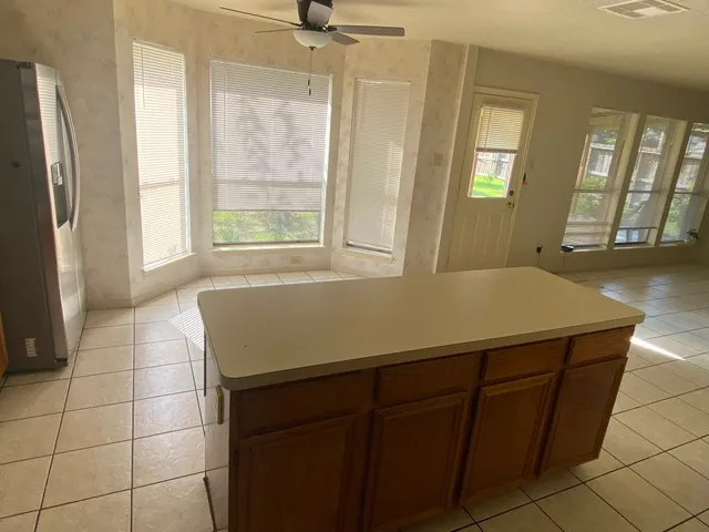 a bathroom with a granite countertop sink a mirror and shower