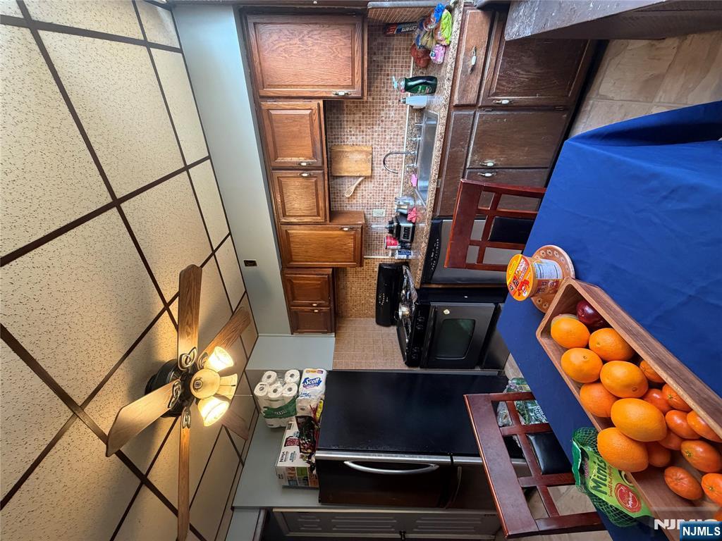 373 McKinley Street Fairview, NJ 07022 - Photo 2 of 8 a kitchen with stainless steel appliances granite countertop a sink and cabinets