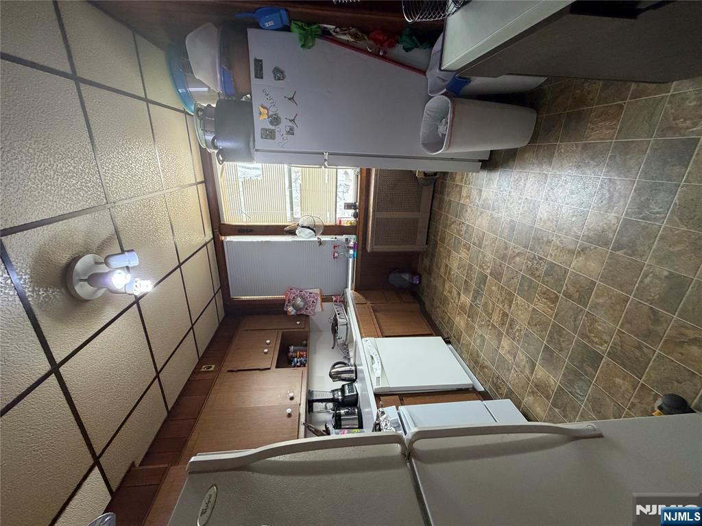 373 McKinley Street Fairview, NJ 07022 - Photo 5 of 8 a kitchen with a sink a refrigerator and cabinets